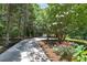Long, paved driveway lined with mature trees and landscaping, leading to a charming home at 6380 Concord Rd, Cumming, GA 30028