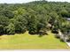 Expansive front yard featuring lush green grass and mature trees, offering a serene and private setting at 6380 Concord Rd, Cumming, GA 30028