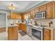 Open kitchen boasts stainless steel appliances, tile flooring, and ample cabinet space at 6380 Concord Rd, Cumming, GA 30028