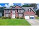 Charming two-story brick home with manicured lawn, two-car garage and classic curb appeal at 1455 Duren Farms Dr, Lithonia, GA 30058