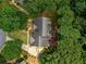 Aerial view of a home with a well-maintained roof, surrounded by lush greenery, and a winding driveway at 755 Creek Wind Ct, Johns Creek, GA 30097