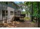 Backyard featuring wooden deck, stairs, mature trees, and lush landscaping at 755 Creek Wind Ct, Johns Creek, GA 30097
