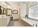 Bright bathroom with dual vanities, soaking tub, and a decorative window at 755 Creek Wind Ct, Johns Creek, GA 30097