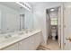 Bright bathroom featuring a double sink vanity, large mirror and tiled floors at 755 Creek Wind Ct, Johns Creek, GA 30097