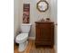 Charming powder room with hardwood floors, carved vanity, and octagonal mirror at 755 Creek Wind Ct, Johns Creek, GA 30097