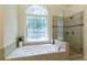 Bathroom featuring a soaking tub with jets and a glass-enclosed shower at 755 Creek Wind Ct, Johns Creek, GA 30097