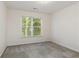 Empty bedroom with a window and neutral colored carpet at 755 Creek Wind Ct, Johns Creek, GA 30097