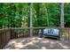Wooden deck with a black bench and wooded views at 755 Creek Wind Ct, Johns Creek, GA 30097