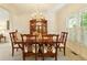 Traditional dining room with wood table, chairs, and chandelier; natural light floods in from a large window at 755 Creek Wind Ct, Johns Creek, GA 30097