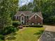 Traditional brick home with a manicured lawn, mature trees, and elegant landscaping at 755 Creek Wind Ct, Johns Creek, GA 30097