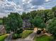 Aerial view of a traditional brick home with mature trees and a well-maintained lawn at 755 Creek Wind Ct, Johns Creek, GA 30097