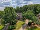 Aerial view of a well-maintained brick home with mature trees and lush landscaping at 755 Creek Wind Ct, Johns Creek, GA 30097