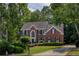 Traditional brick home with manicured landscaping, mature trees and a curved driveway at 755 Creek Wind Ct, Johns Creek, GA 30097