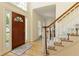 Foyer with hardwood floors, stairs with white railings and paneled front door with sidelight at 755 Creek Wind Ct, Johns Creek, GA 30097