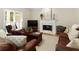 Comfortable living room featuring hardwood floors, a fireplace, and cozy leather furniture at 755 Creek Wind Ct, Johns Creek, GA 30097