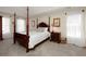 Bright bedroom featuring a four-poster bed, carpet, and lots of natural light at 755 Creek Wind Ct, Johns Creek, GA 30097