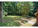 Expansive backyard with mature trees, a patio area, and room for outdoor activities at 104 Southfork Dr, Woodstock, GA 30189
