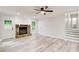 Open-concept living room boasts a stone fireplace, plenty of natural light, and wood-look floors at 104 Southfork Dr, Woodstock, GA 30189