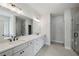 Modern bathroom featuring double vanity, a large mirror, shower with glass door, and tiled floors at 3131 Stonegate Sw Dr, Atlanta, GA 30331