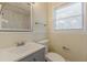 Updated bathroom with modern vanity, toilet, tiled shower, and window for natural light at 1885 N Druid Hills Ne Rd, Atlanta, GA 30319