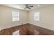 Empty bedroom with refinished dark hardwood flooring, ceiling fan, and two windows at 1885 N Druid Hills Ne Rd, Atlanta, GA 30319