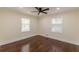 Comfortable bedroom with two windows allowing natural light and featuring a ceiling fan and hardwood flooring at 1885 N Druid Hills Ne Rd, Atlanta, GA 30319
