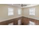 Generously sized bedroom featuring hardwood floors, a ceiling fan, and natural light from three windows at 1885 N Druid Hills Ne Rd, Atlanta, GA 30319