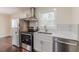 Cozy kitchen features stainless steel appliances, modern white cabinetry, and hardwood floors at 1885 N Druid Hills Ne Rd, Atlanta, GA 30319