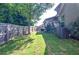 A well-maintained backyard features a grassy lawn, wooden fence and mature trees, offering ample space for outdoor activities at 2436 Loughridge Dr, Buford, GA 30519