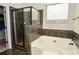 The modern bathroom features a large tub, tiled shower, and tile floors for an elegant design at 2436 Loughridge Dr, Buford, GA 30519