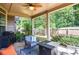 Relaxing covered patio with grill, seating, and landscaped yard perfect for entertaining outdoors and enjoying nature at 2436 Loughridge Dr, Buford, GA 30519