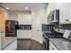 Modern kitchen features stainless steel appliances, granite countertops, dark backsplash, and beautiful flooring at 2436 Loughridge Dr, Buford, GA 30519