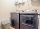 Modern laundry room with front load washer and dryer, shelving, and white walls at 2436 Loughridge Dr, Buford, GA 30519