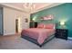 Inviting bedroom features a tray ceiling, a large bed, and black furnishings against an accent wall at 2436 Loughridge Dr, Buford, GA 30519