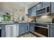 Well-equipped kitchen with stainless steel appliances, gray cabinets, and view into the dining and living room at 655 Mead Se St # 3, Atlanta, GA 30312