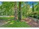 Green backyard featuring mature trees and retaining wall at 6600 N Beulah Rd, Lithia Springs, GA 30122