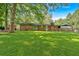 Expansive, lush backyard featuring a brick home, mature trees, and a well-maintained lawn at 6600 N Beulah Rd, Lithia Springs, GA 30122