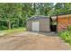 View of the backyard storage building with garage door, and partial view of the home at 6600 N Beulah Rd, Lithia Springs, GA 30122