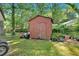 View of the backyard with a storage shed, landscaping plants, and a well-maintained lawn at 6600 N Beulah Rd, Lithia Springs, GA 30122