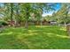 Large backyard with lush grass, trees, and a quaint brick house at 6600 N Beulah Rd, Lithia Springs, GA 30122