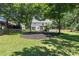 Expansive backyard featuring a lush lawn, mature trees, and charming swing set, perfect for outdoor relaxation and entertainment at 161 Forestview Dr, Suwanee, GA 30024