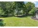 Large, well-maintained backyard with a manicured lawn, mature trees, and a cozy swing set, ideal for Gathering enjoyment at 161 Forestview Dr, Suwanee, GA 30024