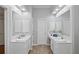 Bright bathroom featuring double vanities with white countertops, large mirrors, and overhead lighting at 161 Forestview Dr, Suwanee, GA 30024
