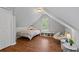 Cozy room featuring sloped ceilings, hardwood floors, and a comfortable reading nook at 161 Forestview Dr, Suwanee, GA 30024