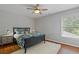Well-lit bedroom with hardwood floors, a ceiling fan, and a cozy bed with a floral comforter at 161 Forestview Dr, Suwanee, GA 30024