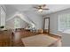 Spacious room with hardwood floors, sloped ceiling, ceiling fan and large rug at 161 Forestview Dr, Suwanee, GA 30024