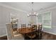 Elegant dining area with wood table, chandelier, and views of a modern kitchen at 161 Forestview Dr, Suwanee, GA 30024