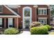 Close-up of the red brick home's elegant front door and manicured landscaping at 161 Forestview Dr, Suwanee, GA 30024