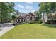 Beautiful red brick home featuring a large manicured lawn and mature trees at 161 Forestview Dr, Suwanee, GA 30024