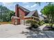 Side view of home featuring a three-car garage and well maintained landscaping at 161 Forestview Dr, Suwanee, GA 30024